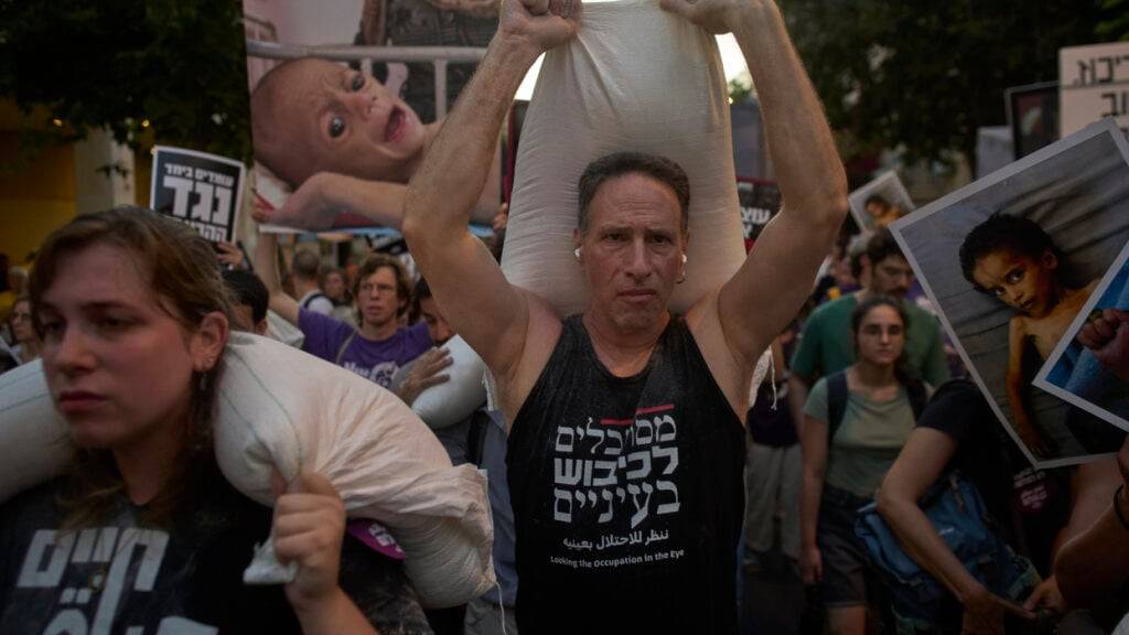 Israelische Aktivisten protestieren gegen den Krieg im Gazastreifen, Israels Maßnahmen zur Lebensmittelverteilung und die Zwangsumsiedlung von Palästinensern. Foto: Ohad Zwigenberg/AP/dpa