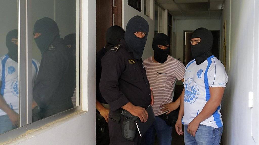 Polizisten schaffen sich Zugang zu den Büros der Kanzlei Mossack Fonseca in El Salvador. Die Razzia fand im Zuge der sogenannten Panama-Papers-Enthüllungen statt.