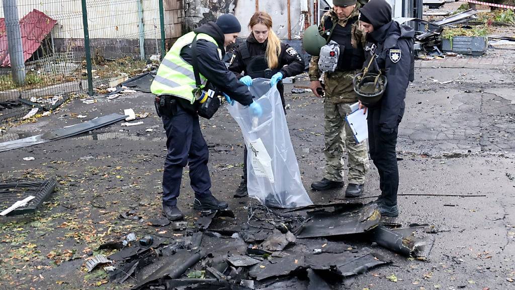 ARCHIV - Ordnungskräfte heben nach einem russischen Drohnenangriff die Bruchstücke einer russischen Drohne auf. In der ukrainischen Hauptstadt Kiew lösten die Trümmer abgeschossener Kampfdrohnen in der Nacht auf Montag Brände aus. Foto: --/Ukrinform/dpa