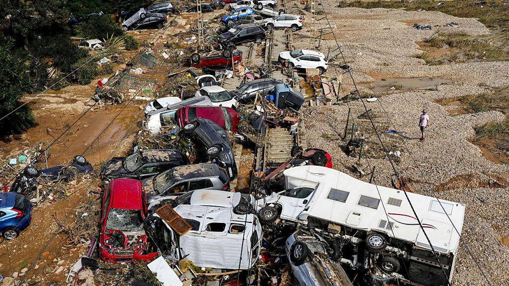 Ein Mann steht neben Autos, die nach dem Unwetter übereinander liegen. Foto: Manu Fernandez/AP/dpa