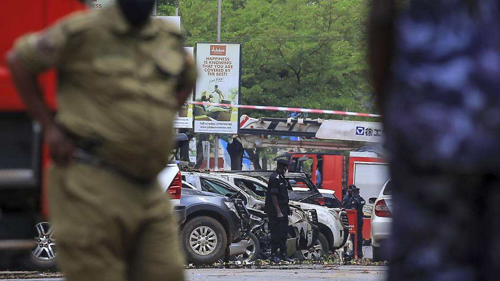 Sicherheitskräfte sichern den Ort einer Explosion in der Nähe des Parlamentsgebäudes in Kampala. Zwei heftige Explosionen haben die Hauptstadt Ugandas am Dienstagmorgen (16.11.2021) erschüttert, die Zahl der Todesopfer ist inzwischen auf 13 gestiegen. Foto: Hajarah Nalwadda/AP/dpa