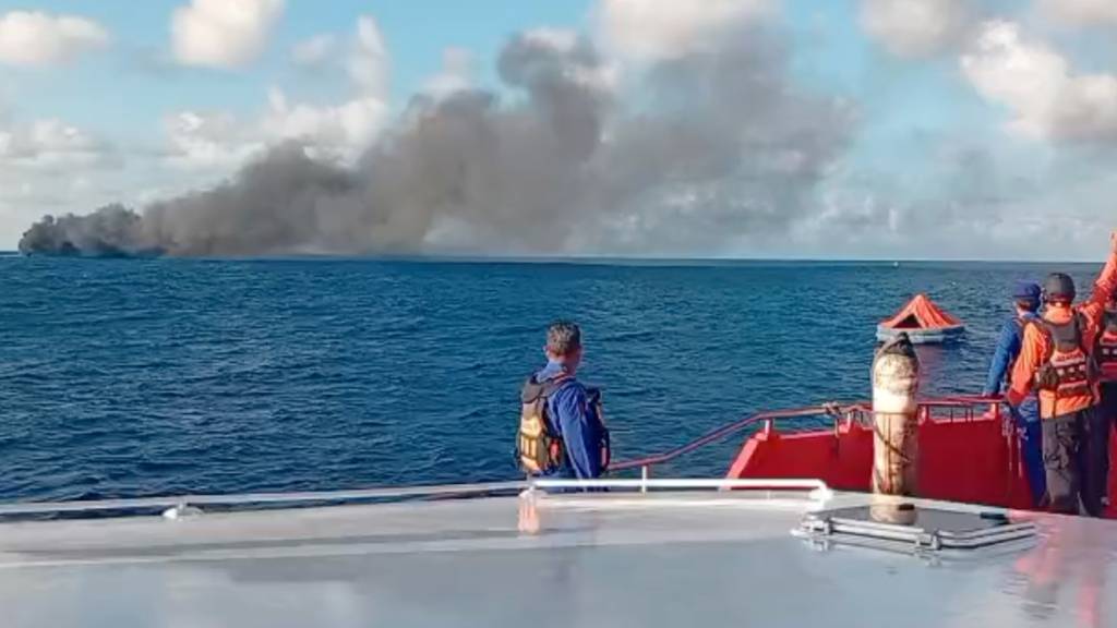 HANDOUT - Auf diesem Bild, das aus einem von der indonesischen nationalen Such- und Rettungsbehörde (BASARNAS) veröffentlichten Video stammt, beobachtet die Besatzung eines Rettungsschiffs, wie Rauch aus einer Passagierfähre aufsteigt. Foto: Uncredited/BASARNAS/AP/dpa