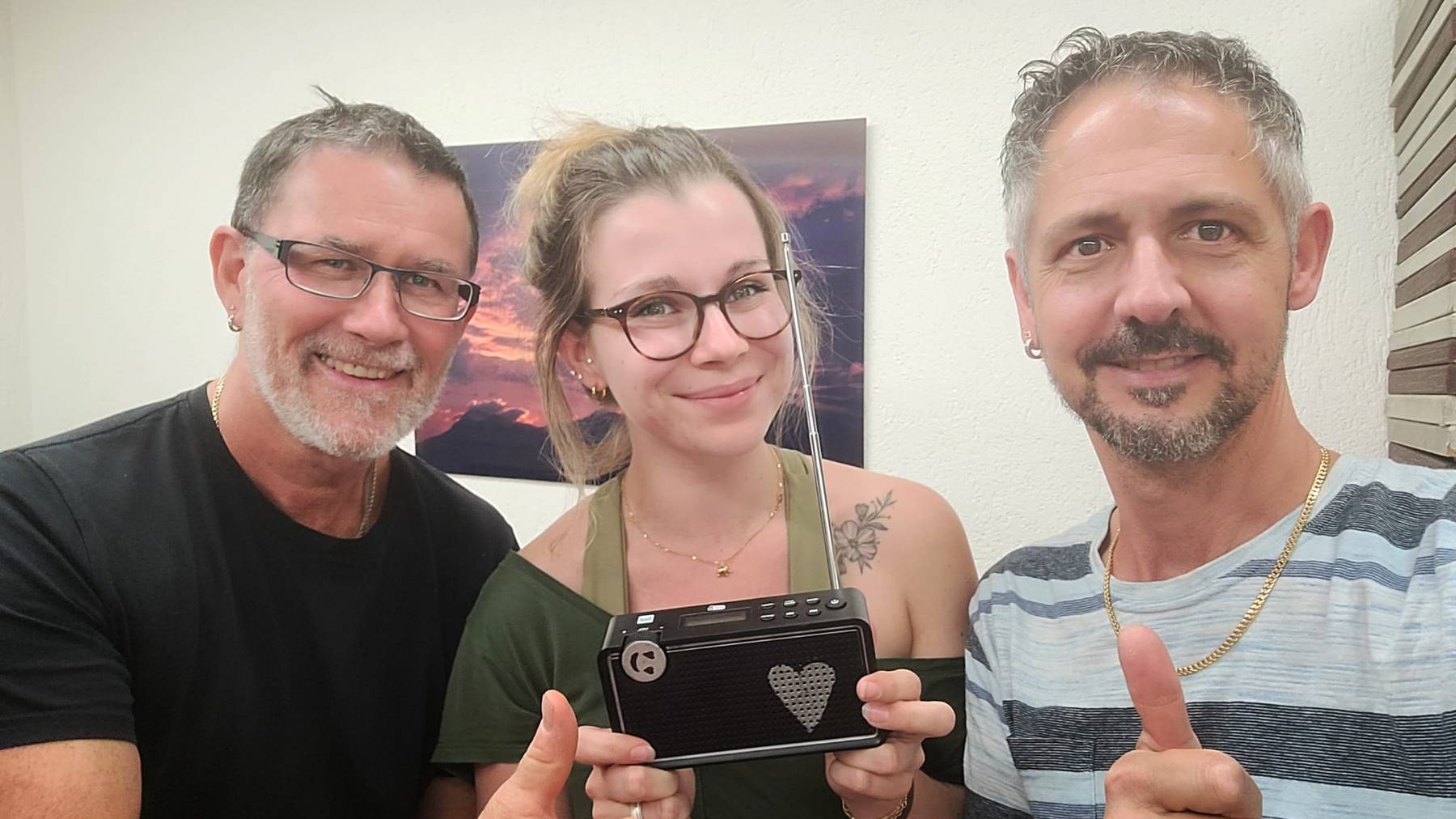 Siegerin Rebecca und ihre zwei Arbeitskollegen beim Radiohören.  