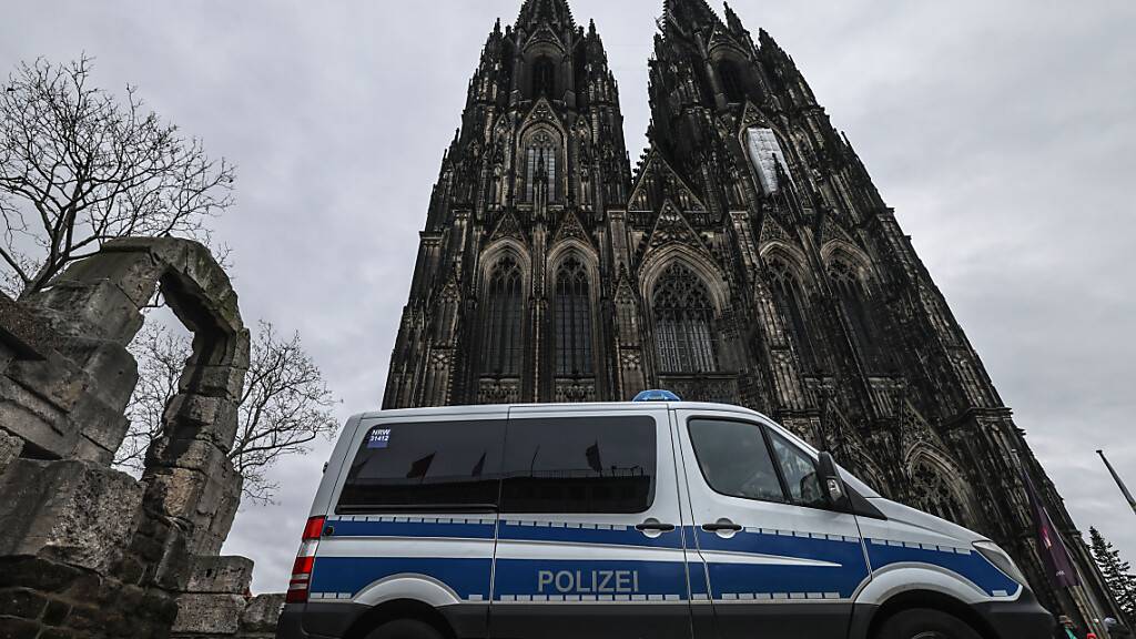 Ein Polizeifahrzeug steht vor dem Dom. Nach dem Terroralarm bleibt der Kölner Dom für Besucher geschlossen. Foto: Oliver Berg/dpa