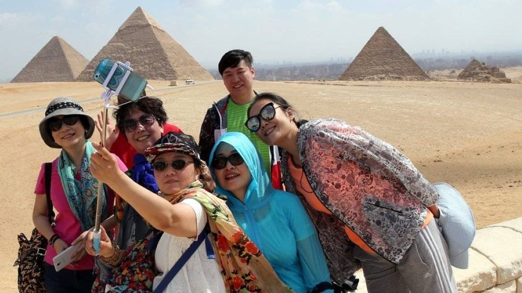 Touristen posieren vor den Pyramiden in Gizeh für ein Selfie. (Archiv)