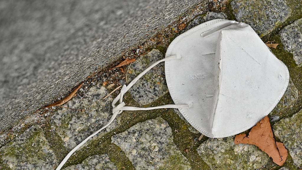 ARCHIV - Eine FFP2 Maske liegt auf einem Gehweg. Foto: Patrick Pleul/dpa-Zentralbild/dpa