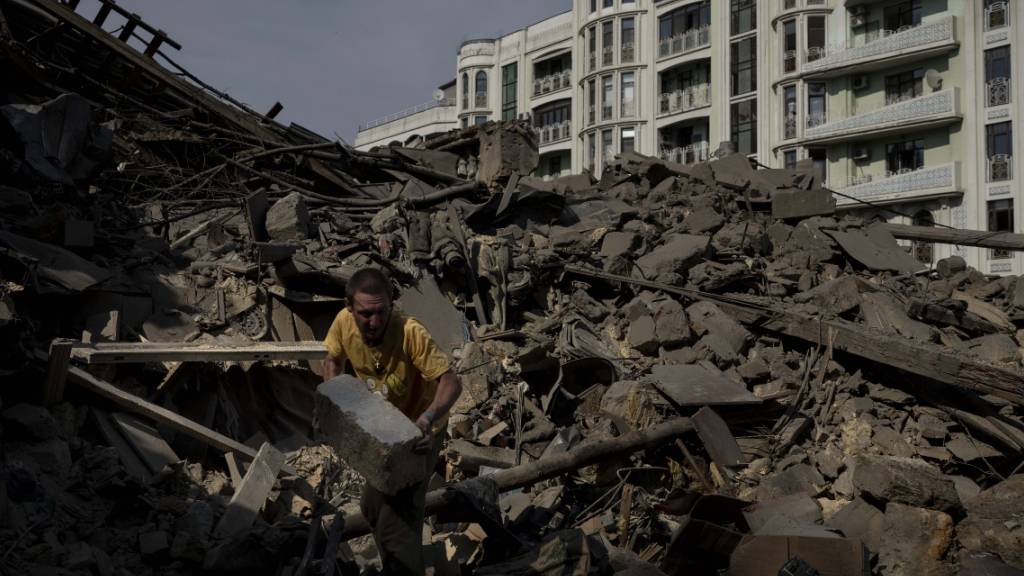 Ein Mann räumt Trümmer eines durch Raketenbeschuss zerstörten Wohnhauses in der Stadt Odessa weg. Foto: Jae C. Hong/AP