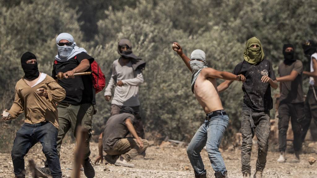 ARCHIV - Rechtsgerichtete israelische Siedler werfen Steine auf palästinensische Dorfbewohner während eines Angriffs auf das Dorf im Westjordanland Turmusaya. Foto: Ilia Yefimovich/dpa