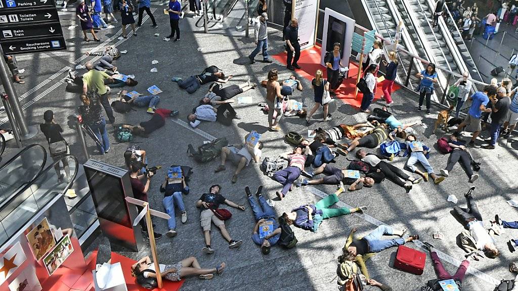 Menschen sollen auf dem Boden bleiben statt mit dem Flugzeug abzuheben: Kurz-Streik von Klimaaktivisten am Flughafen Zürich.