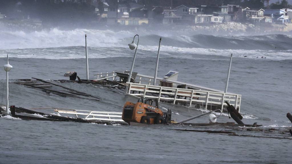Ein Teil einer Werft und andere Trümmer treiben im Meer. Foto: Shmuel Thaler/The Santa Cruz Sentinel/AP/dpa - ACHTUNG: Nur zur redaktionellen Verwendung und nur mit vollständiger Nennung des vorstehenden Credits