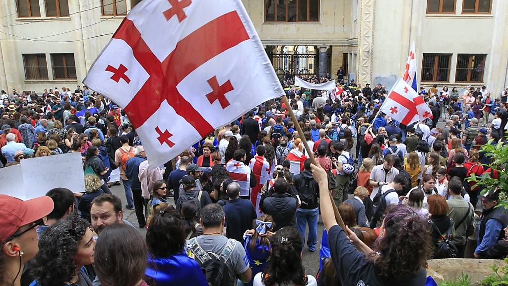 Demonstranten schwenken georgische Nationalfahnen während eines Protestes der Opposition gegen das Gesetz über ausländische Einflussnahme vor dem Parlamentsgebäude. Foto: Shakh Aivazov/AP/dpa