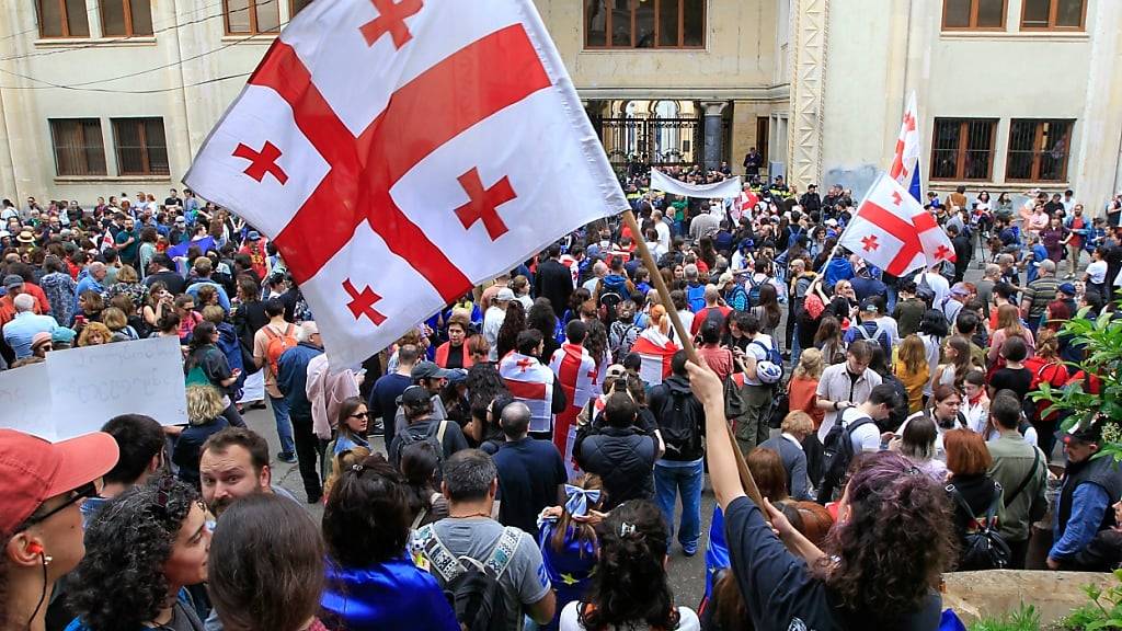 Demonstranten schwenken georgische Nationalfahnen während eines Protestes der Opposition gegen das Gesetz über ausländische Einflussnahme vor dem Parlamentsgebäude. Foto: Shakh Aivazov/AP/dpa