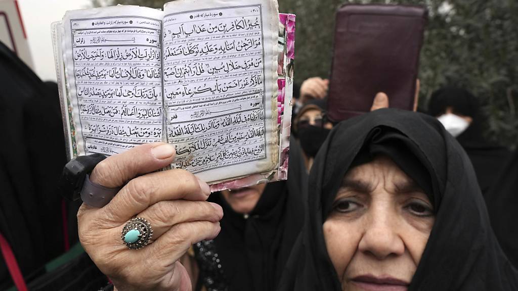 ARCHIV - Eine Frau hält in Teheran ein Exemplar des Korans während eines Protests gegen die Koranverbrennung eines schwedisch-dänischen Politikers. In Dänemark wird es künftig verboten sein, den Koran oder andere religiöse Schriften zu verbrennen. Foto: Vahid Salemi/AP/dpa
