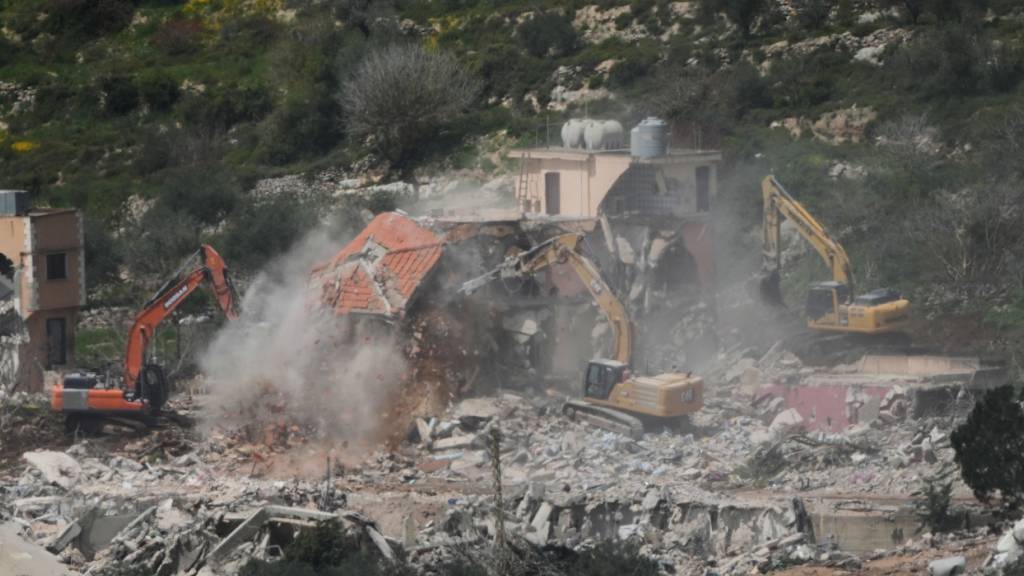 ARCHIV - Israelische Bulldozer zerstören Häuser im Südlibanon, gesehen von Nordisrael aus. Foto: Ariel Schalit/AP/dpa