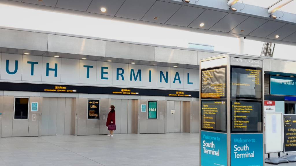 Eine Frau wartet im Süd-Terminal auf einen Aufzug im Flughafen Gatwick. Wegen der in Großbritannien entdeckten neuen Variante des Coronavirus werden Flüge von dort nach Deutschland und in andere EU-Staaten weitgehend gestoppt. Foto: Gareth Fuller/PA Wire/dpa