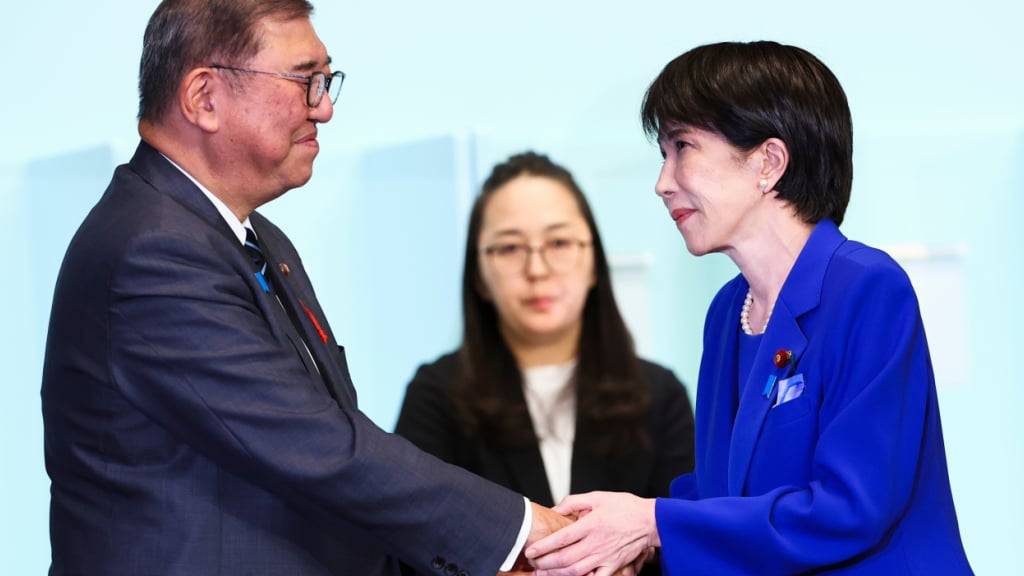Die neu gewählte Vorsitzende der Liberaldemokratischen Partei Japans (LDP), Sanae Takaichi, schüttelt Ministerpräsident Shigeru Ishiba die Hand. Foto: Kim Kyung-Hoon/Pool Reuters via AP/dpa
