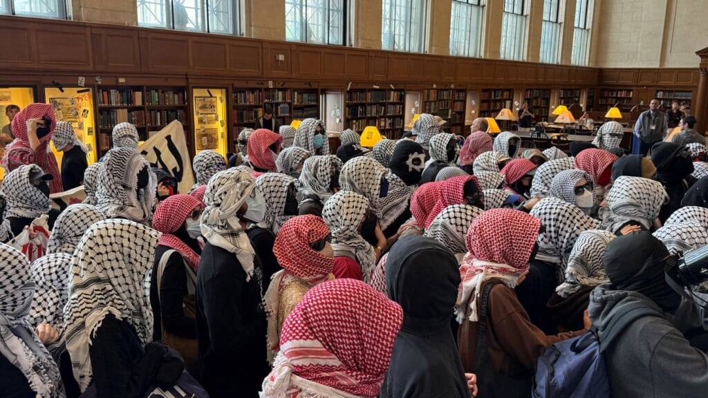 Demonstranten protestieren vermummt in der Hauptbibliothek auf dem New Yorker Campus der Columbia Universität. Foto: Johanna Hänsel/dpa