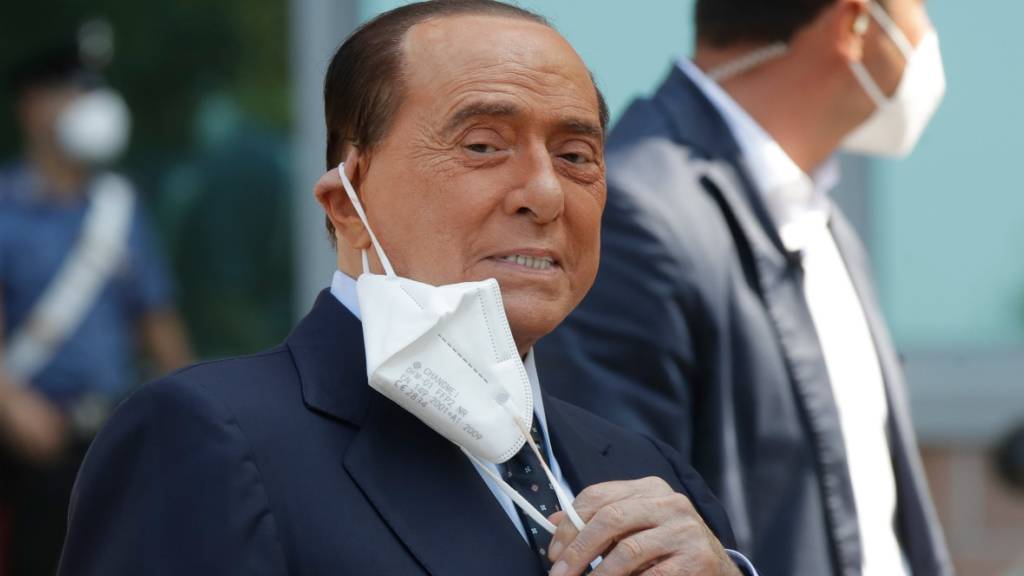 ARCHIV - Silvio Berlusconi, ehemaliger Ministerpräsident von Italien, nimmt seinen Mund-Nasen-Schutz ab, nachdem er das Krankenhaus San Raffaele verlassen hat. Berlusconi war ins Krankenhaus eingeliefert worden, um seine Corona-Infektion zu überwachen, nachdem er positiv auf Covid-19 getestet worden war. Foto: Luca Bruno/AP/dpa