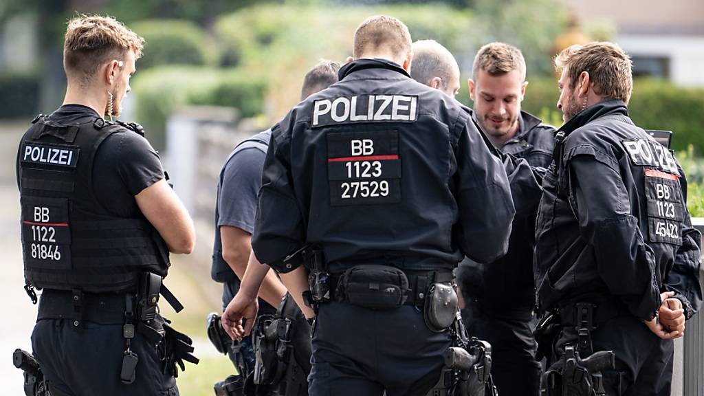Polizisten koordinieren die Such in einem Wohngebiet in Teltow nach einem Wildtier. Foto: Fabian Sommer/dpa