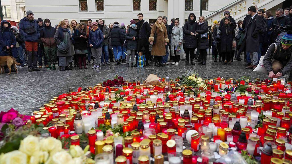 Trauernde legen Blumen für die Opfer der Schusswaffenattacke an der Karls-Universität in Prag nieder. Foto: Petr David Josek/AP/dpa