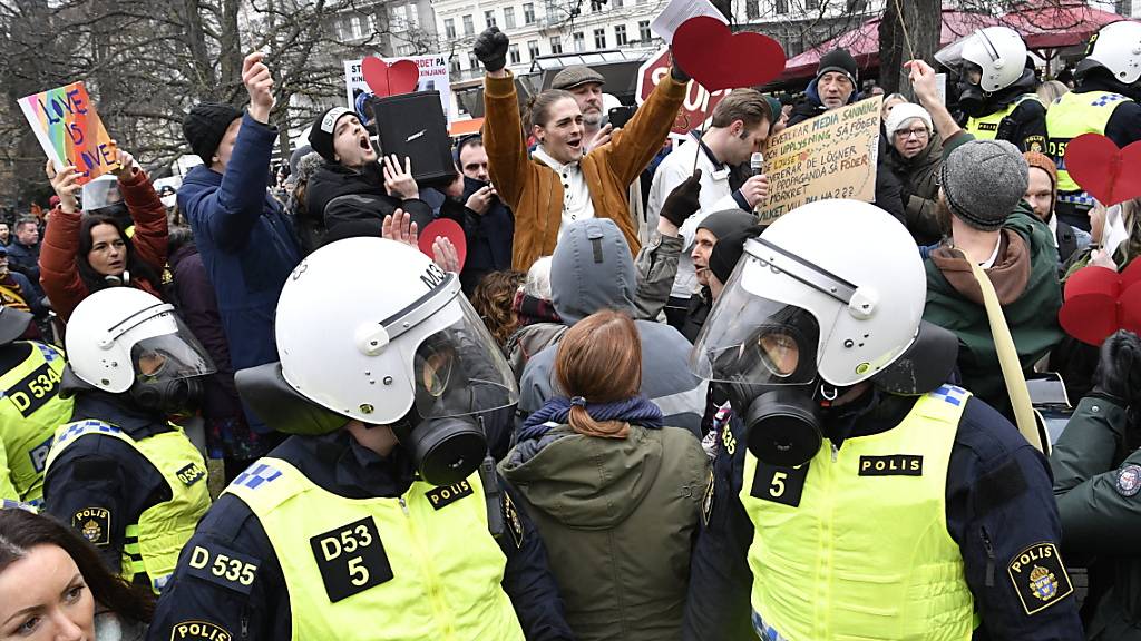 Bereitschaftspolizisten stehen auf einer Straße bei einer Demonstration gegen die Massnahmen zur Eindämmung des Coronavirus. Foto: Johan Nilsson/TT NEWS AGENCY/AP/dpa
