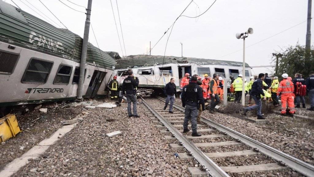 Rettungskräfte bergen Passagiere aus den Wagen des verunglückten Zugs in der Nähe von Mailand.