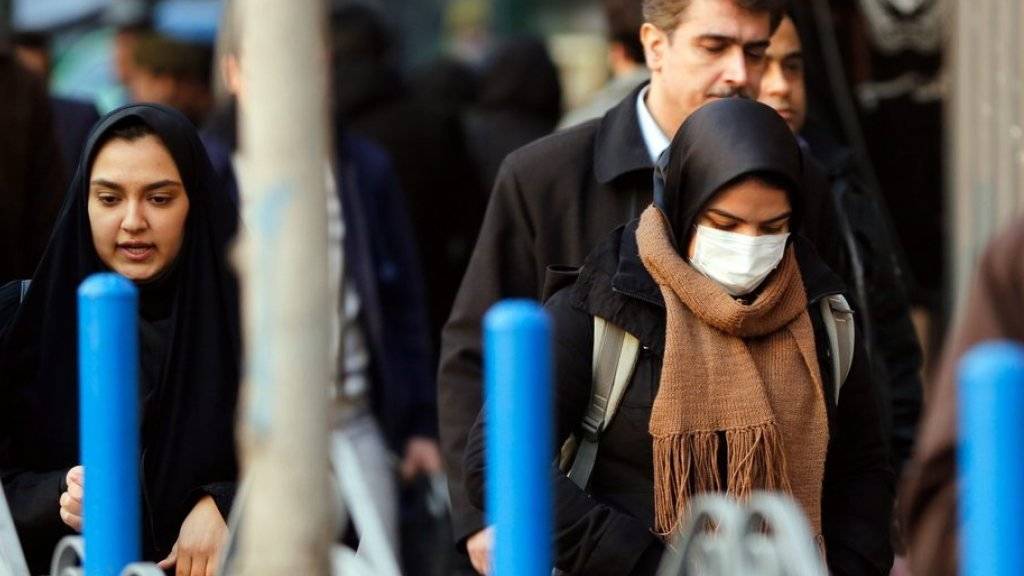 Eine Frau läuft mit einer Atemschutzmaske durch Irans Hauptstadt Teheran. Die Metropole gilt als eine der am stärksten verschmutzten Hauptstädte der Welt