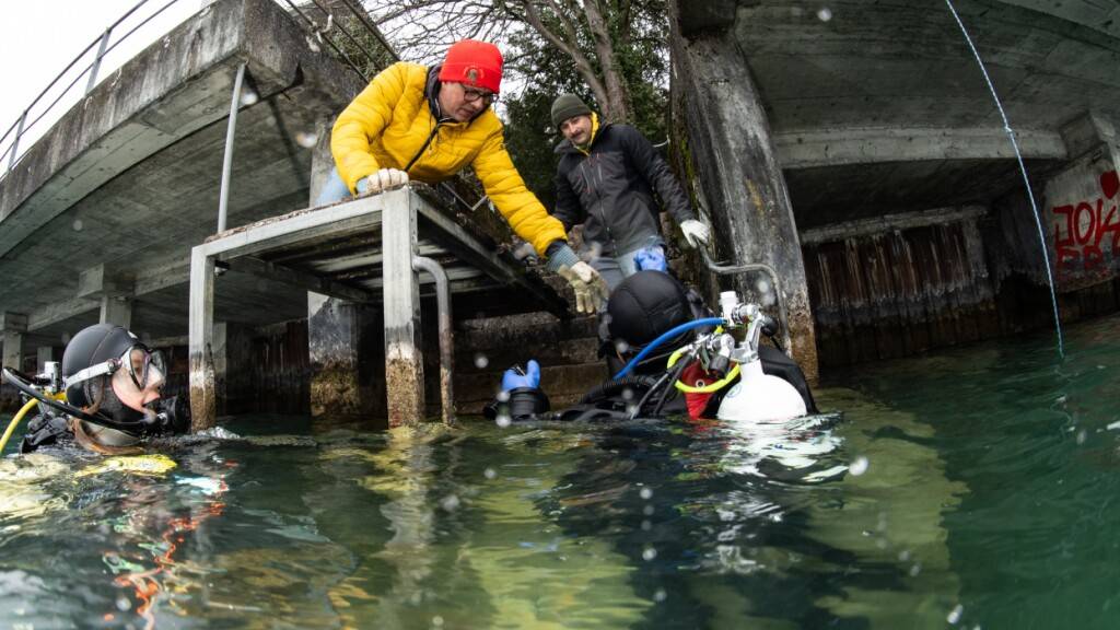 Taucher bringen am Samstag in Gunten Abfall aus dem See an Land.