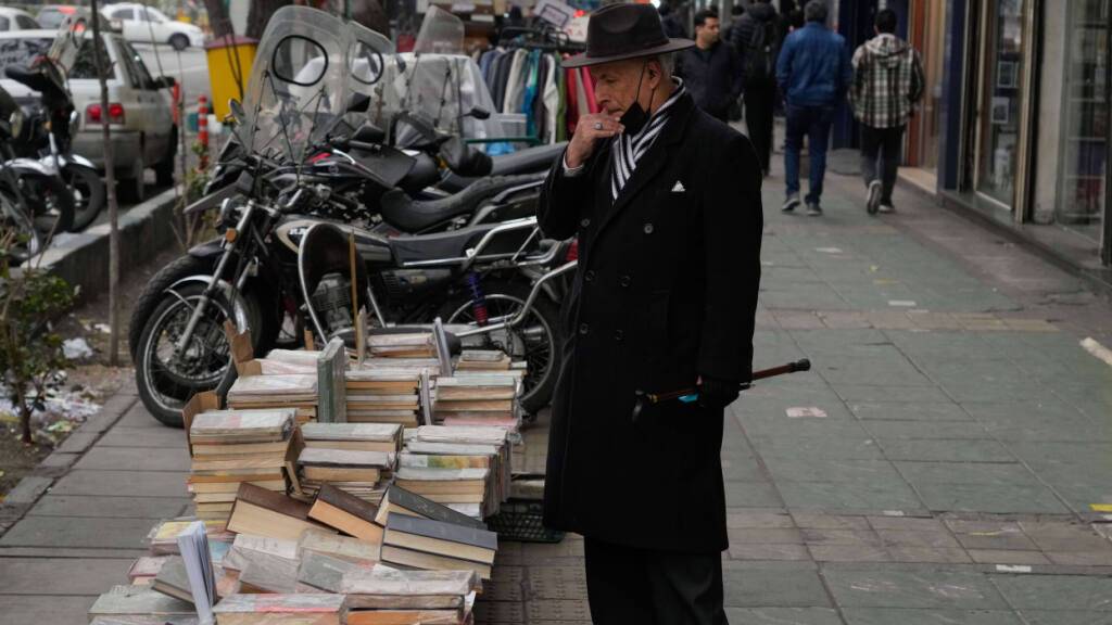 dpatopbilder - Ein Mann betrachtet Bücher, die auf einem Gehweg in der Innenstadt von Teheran zum Verkauf angeboten werden. Foto: Vahid Salemi/AP/dpa