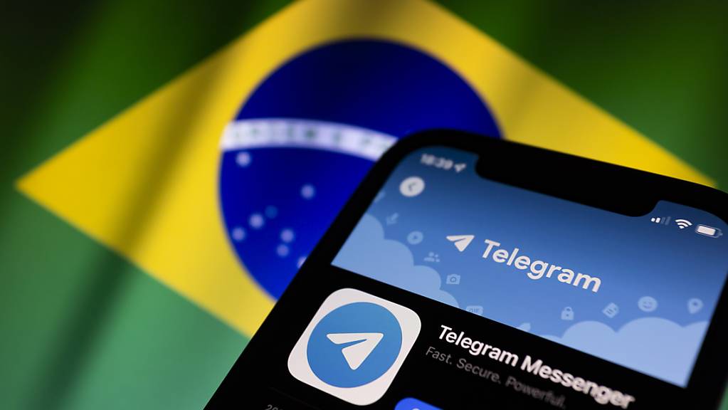 ILLUSTRATION - Das App-Symbol von Telegram wird im App Store auf einem Smartphone angezeigt, während im Hintergrund die Flagge von Brasilien zu sehen ist. Foto: Andre M. Chang/ZUMA Press Wire/dpa