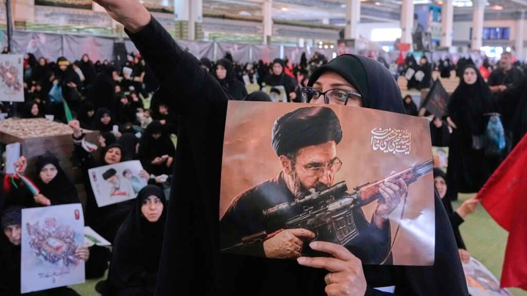 ARCHIV - Eine Frau hält ein Plakat des iranischen Obersten Führers Ajatollah Modschtaba Chamenei. Foto: Vahid Salemi/AP/dpa/Archivbild