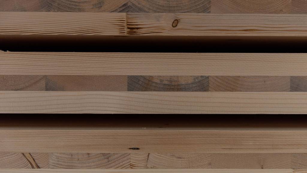 Das leicht verfärbte Holz wird zwischen zwei gute Holzplatten geleimt.