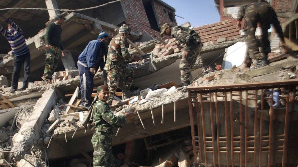 Indische Soldaten und lokale Hilfskräfte bei der Räumung von Erdbebentrümmern in Imphal