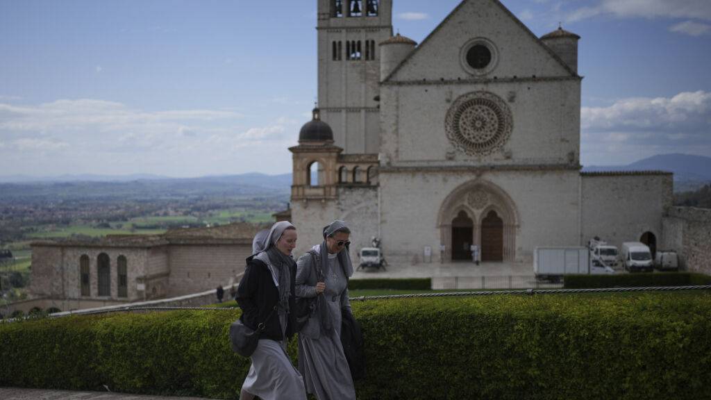 ARCHIV - Nonnen gehen an der päpstlichen Basilika und dem Kloster des Heiligen Franz von Assisi in Assisi vorbei. Foto: Alessandra Tarantino/AP/dpa