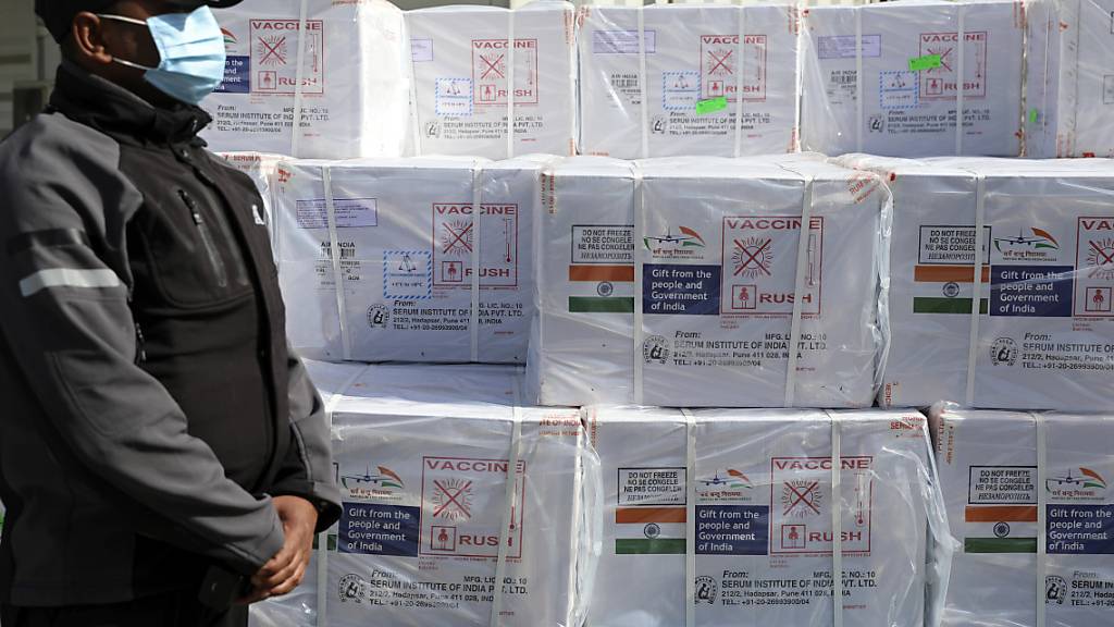 Wachpersonal steht neben einer Lieferung des Corona-Impfstoffes des Herstellers Oxford/AstraZeneca im Zollbereich des Hamid Karzai International Airport. Die indische Regierung spendete dem Land in einer ersten Lieferung 500.000 Impfdosen. Foto: Rahmat Gul/AP/dpa