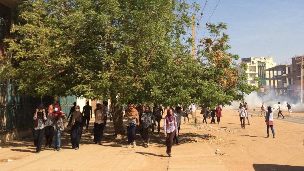 In der sudanesischen Hauptstadt Khartum ziehen sich Protestierende zurück, nachdem die Polizei Tränengas gegen die Regierungsgegner eingesetzt hat. (Archiv)