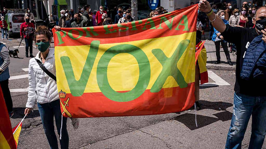 Anhänger der rechtsgerichteten Partei VOX halten eine Spanienfahne mit VOX-Logo auf der Plaza Conde de Casal. Foto: Diego Radames/SOPA Images via ZUMA Wire/dpa