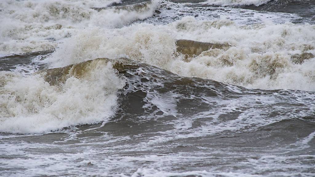 Wellen schlagen an den Ostseestrand. Wegen eines Sturmtiefs sind an der Ostseeküste die ersten Straßen und Uferbereiche vom Hochwasser überschwemmt worden. So standen am Morgen sowohl in Wismar als auch in Kiel und und Flensburg zahlreiche Straßen und Plätze unter Wasser. Foto: Stefan Sauer/dpa