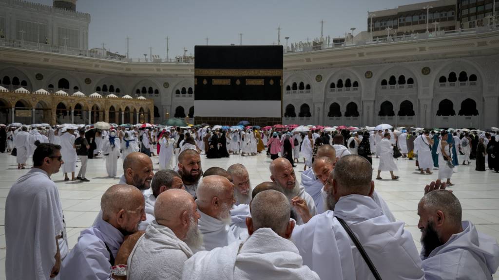 Eine Gruppe muslimischer Pilger diskutiert die Rituale der Umrundung der Kaaba, der heiligsten Stätte des Islam, in der Großen Moschee während der jährlichen Hadsch-Pilgerreise. Foto: Altaf Qadri/AP/dpa