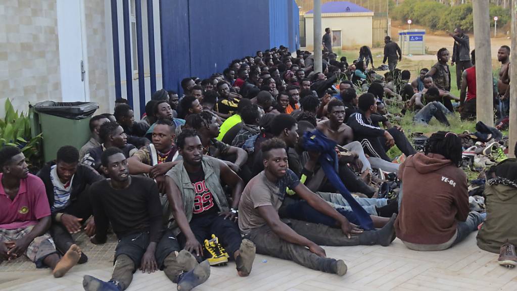 Eine Gruppe von Migranten sitzt in einem Aufnahmezentrum in Melilla. Insgesamt 238 Menschen sind am frühen Donnerstagmorgen über den Grenzzaun zwischen Marokko und Spanien gesprungen. Dabei seien laut Angaben des TV-Senders RTVE drei spanische Polizisten und 18 Migranten verletzt worden. Foto: Uncredited/Europa Press/dpa