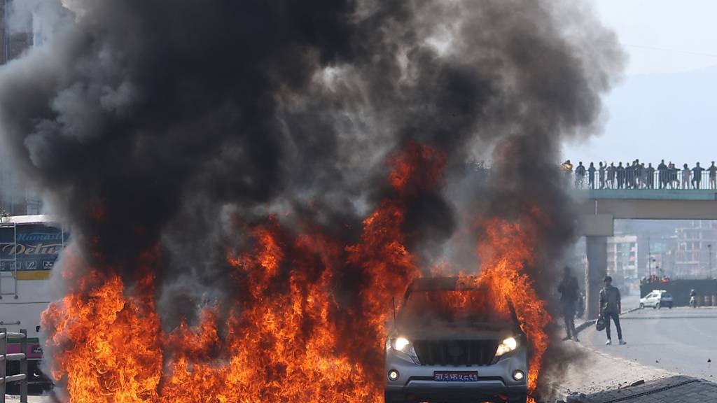 dpatopbilder - Demonstranten verbrennen das Fahrzeug des Ministers für Infrastruktur und Verkehr. Nach Angaben der nepalesischen Polizei starben mindestens zwei Demonstranten bei dem gewaltsamen Protest. Foto: Aryan Dhimal/ZUMA Press Wire/dpa