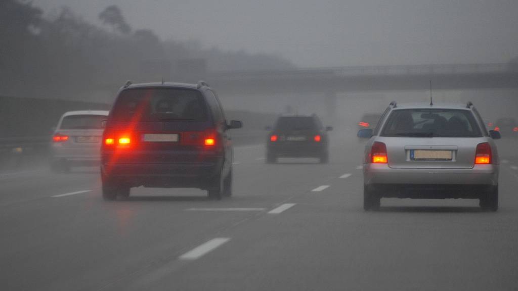 Auto mit eingeschalteter Nebelschlussleuchte fährt auf der Autobahn.