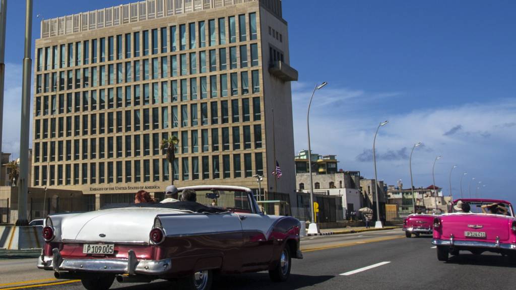 ARCHIV - Touristen fahren in klassischen Cabriolets auf dem Malecon an der Botschaft der USA vorbei. Foto: Desmond Boylan/AP/dpa