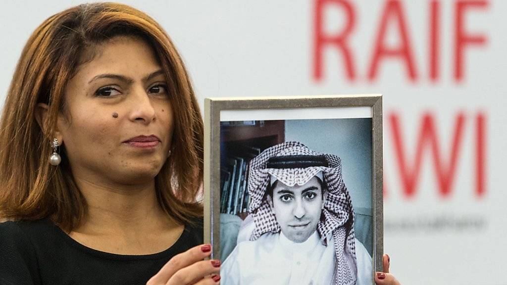 Ein Bild vom inhaftierten saudischen Blogger Raif Badawi, hochgehalten von dessen Frau. Badawis Schwester wurde am Mittwoch in Polizeigewahrsam genommen. (Archiv)