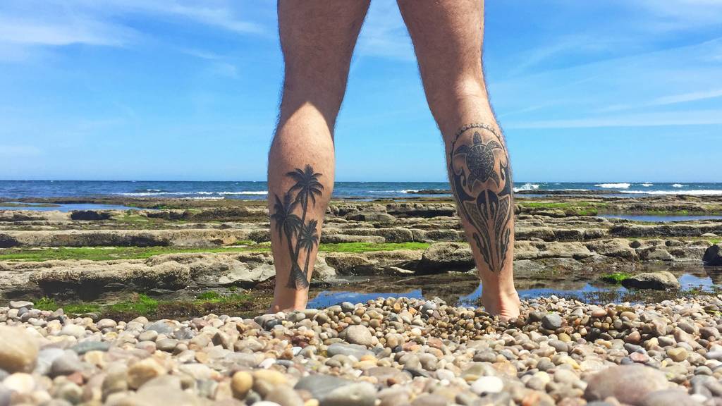 Mann ohne Hose Strand Wasser Tattoos