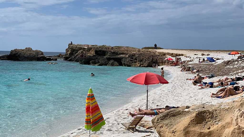 ARCHIV - Menschen liegen am Strand von Is Arutas an der Westküste Sardiniens. Urlauber und Bewohner in Italien müssen sich in den kommenden Tagen auf extreme Hitze einstellen. Für Dienstag und Mittwoch gab das Gesundheitsministerium am Montag für einige Teile Italiens die höchste Hitze-Stufe drei heraus. Foto: Annette Reuther/dpa - ACHTUNG: Verwendung nur im vollen Format