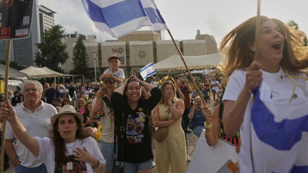 Menschen versammeln sich auf dem Geiselplatz, um die Live-Übertragung der Freilassung des israelisch-amerikanischen Soldaten Edan Alexander aus der Gefangenschaft der Hamas im Gazastreifen zu verfolgen. Foto: Oded Balilty/AP/dpa