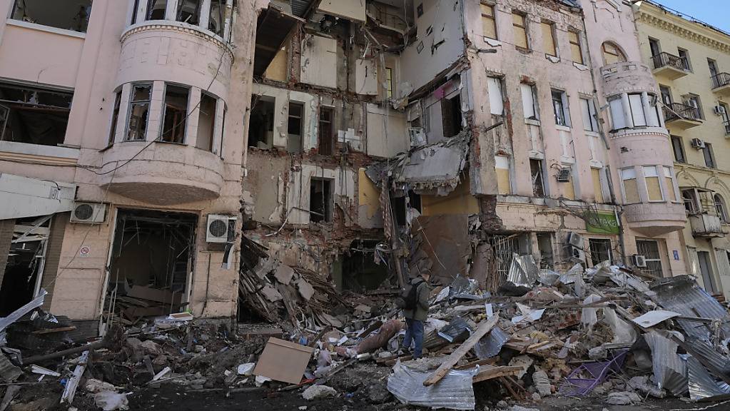 Ein Mann geht an einem zerstörten Gebäude nach einem russischen Angriff in Charkiw vorbei. 