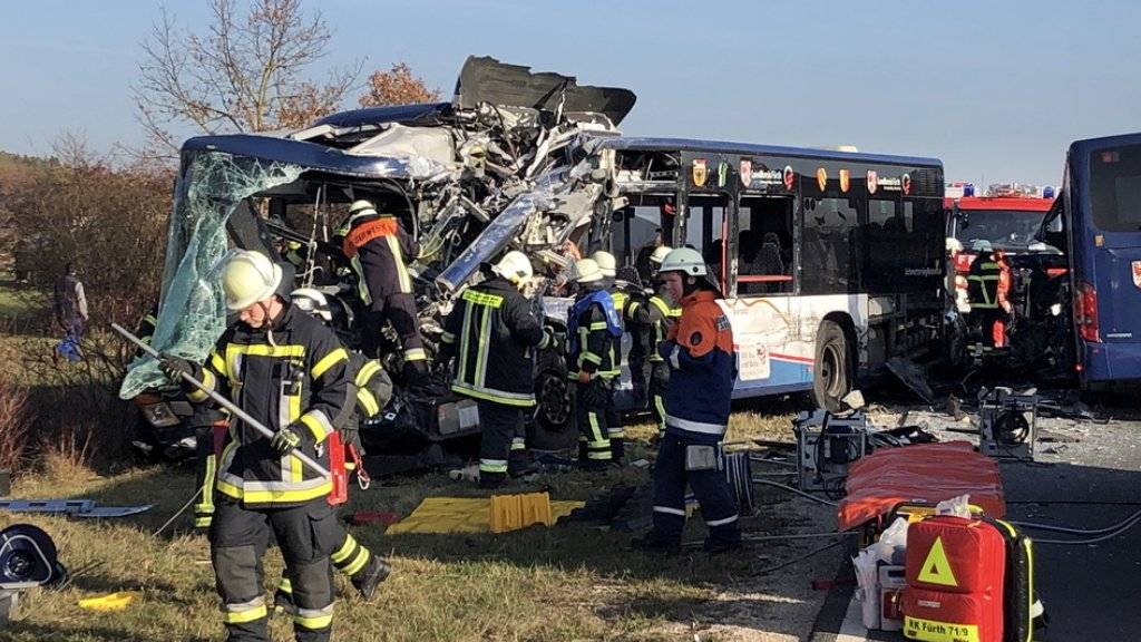Rettungskräfte arbeiten an der Unfallstelle. Bei dem Zusammenstoss von zwei Schulbussen im Landkreis Fürth sind mehrere Kinder schwer verletzt worden.
