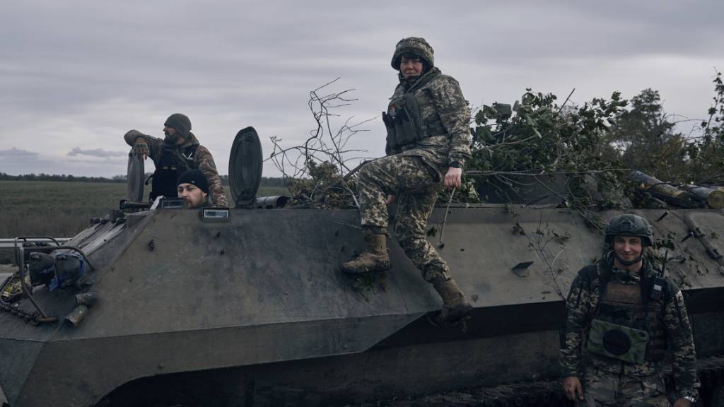 ARCHIV - Ukrainische Soldaten und eine Soldatin (M) posieren für ein Bild mit ihrem gepanzerten Transportfahrzeug in der Nähe von Bachmut, Region Donezk. Mehr als 40 000 Frauen dienen während des russischen Angr iffskrieges in der ukrainischen Armee. (zu dpa «Mehr als 40 000 Frauen dienen in der ukrainischen Armee») Foto: Libkos/AP/dpa